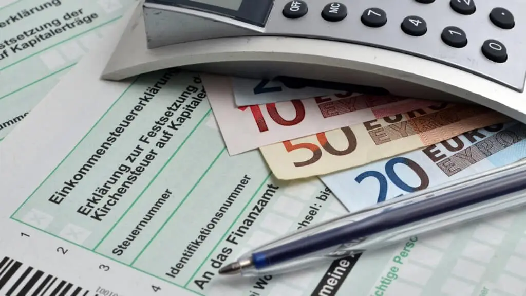 Ein Steuererklärungsformular, Taschenrechner und Bargeld